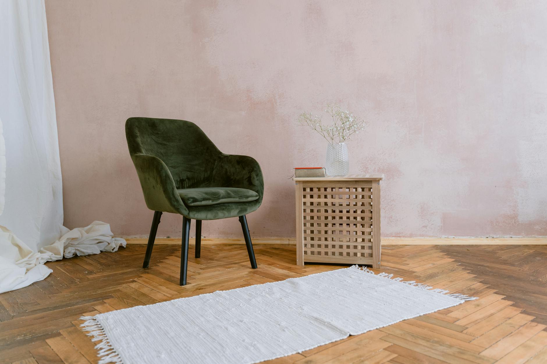 Minimalistyczny pokój z zielonym fotelem, drewnianym stolikiem i miękkim dywanem