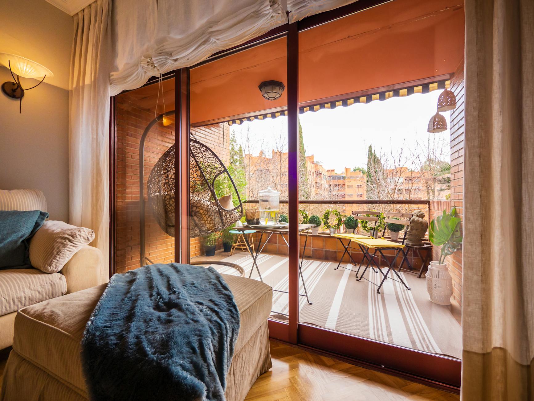 Przytulny balkon w Madrycie z miękkimi siedziskami i roślinami