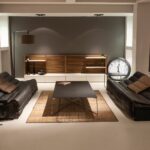 Nowoczesny salon z czarnymi skórzanymi sofami i eleganckim wystrojem